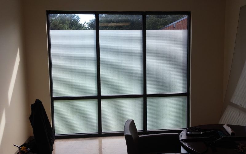 A room with a table and chairs and a large window