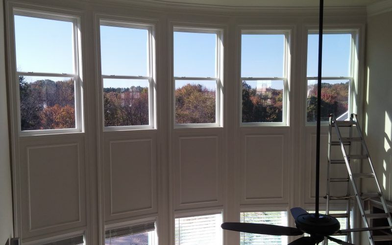 A room with a lot of windows and a ceiling fan.