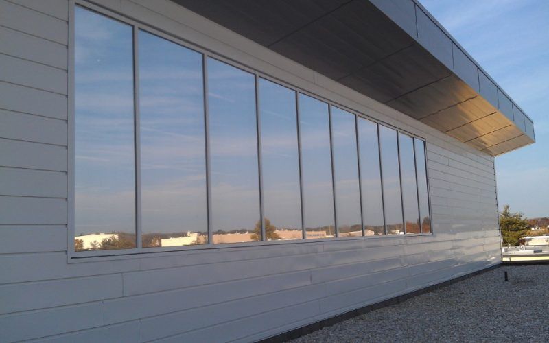 A large window on the side of a building reflecting the sky