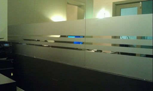 A room with a glass wall and a desk in it.