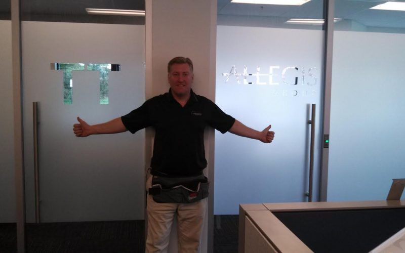 A man giving a thumbs up in front of a door that says tt