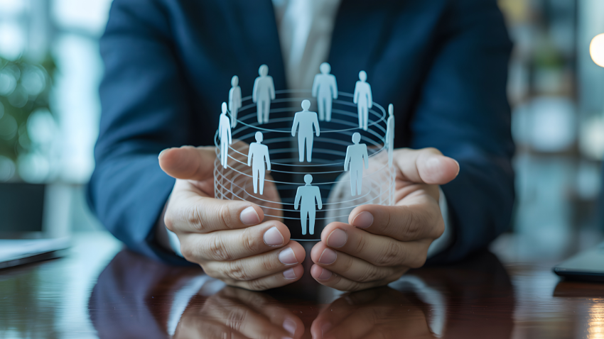 Person in suit holding a glowing sphere of interconnected human figures.
