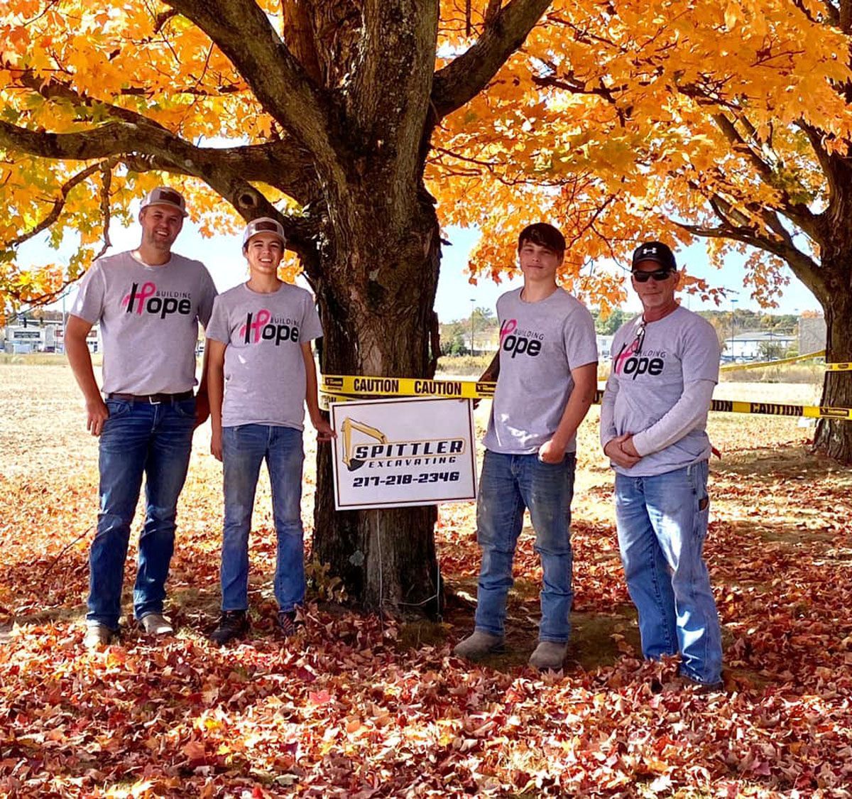 A group of men standing in front of a tree wearing hope shirts