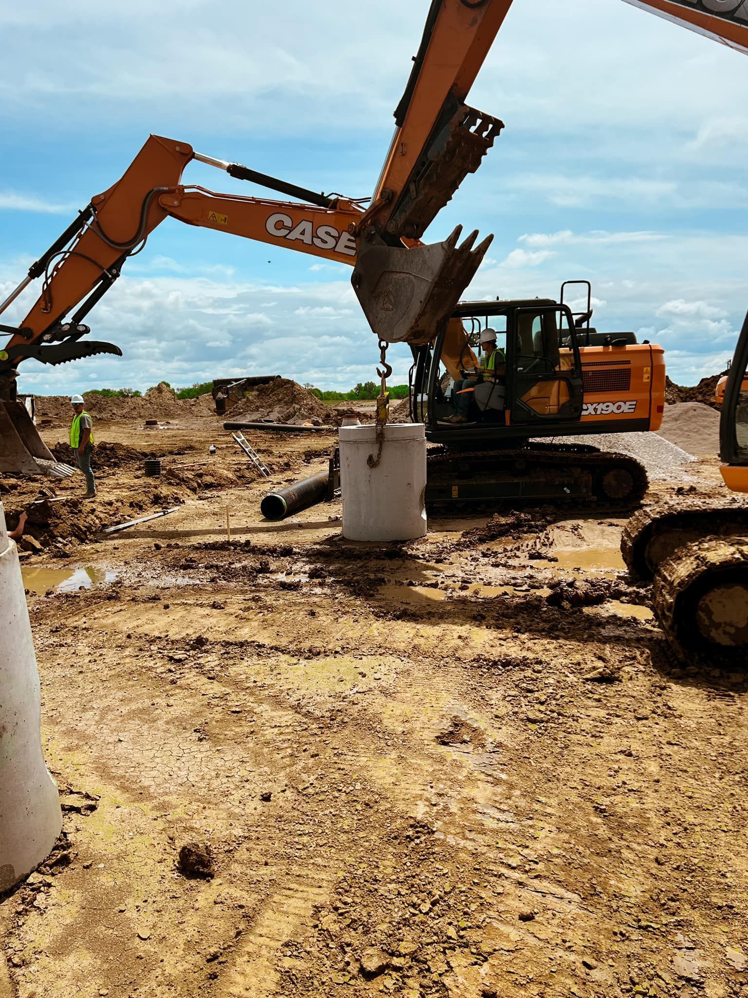 A couple of excavators are working on a construction site.