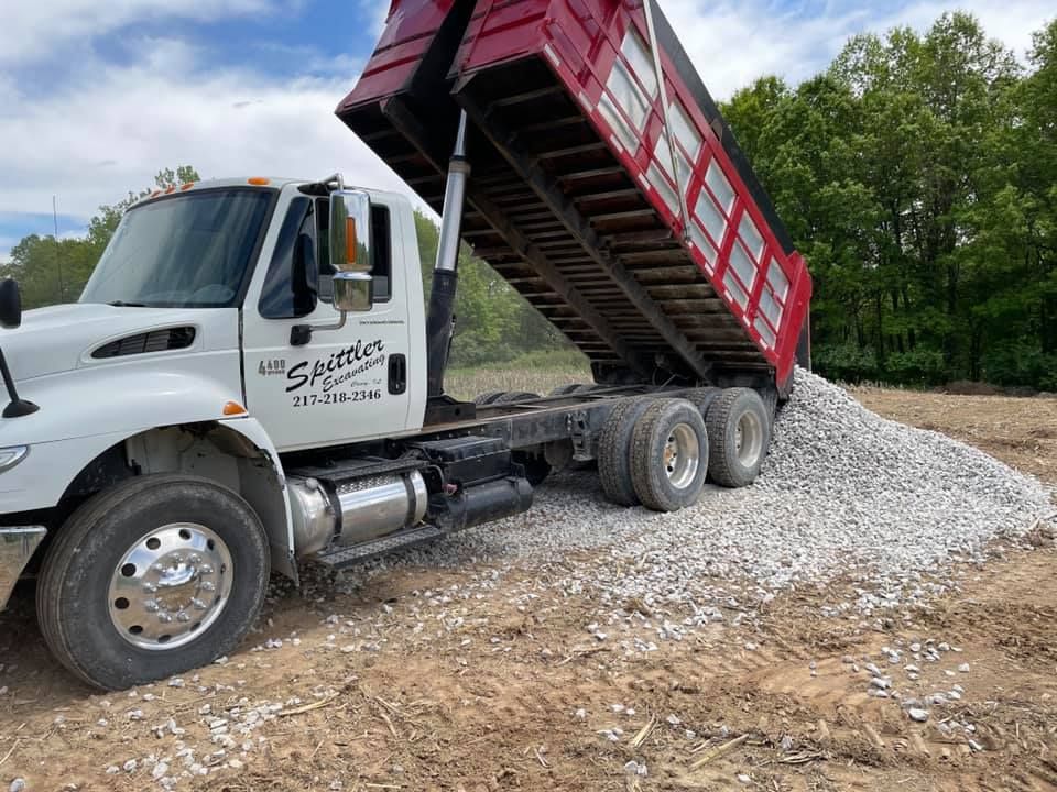 A dump truck is sitting on top of a pile of gravel.