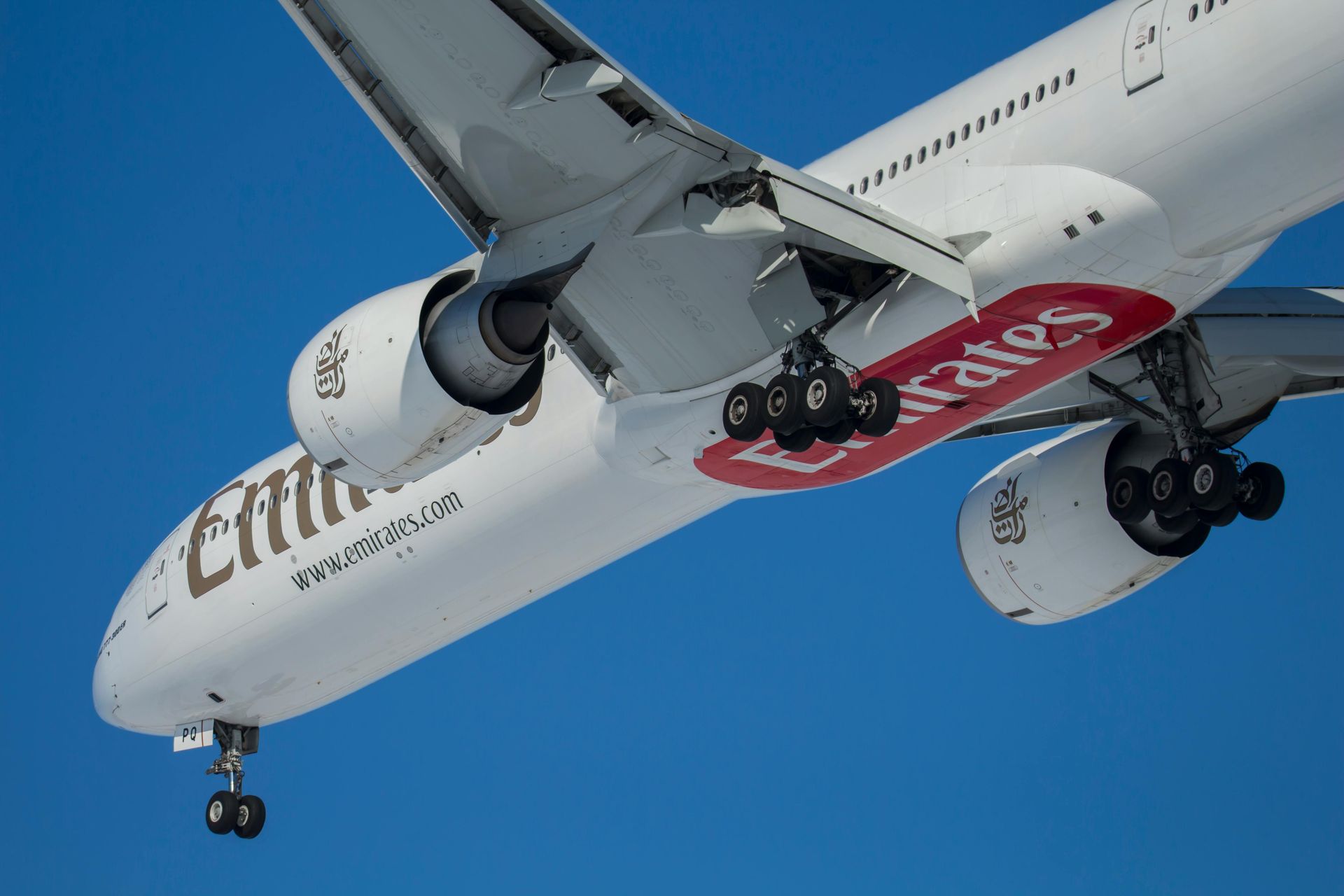 A commercial airline flying high above the clouds on a sunny day.