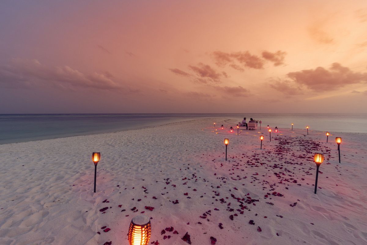 Romantic sandbank setup with couple at sunset in the Maldives