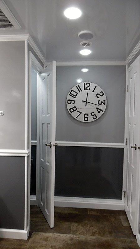A clock is hanging on a wall in a hallway.