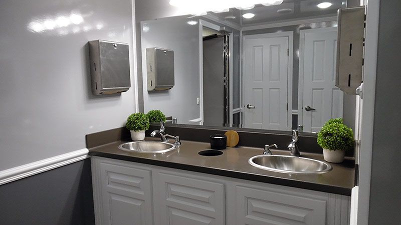 A bathroom with two sinks and a large mirror.