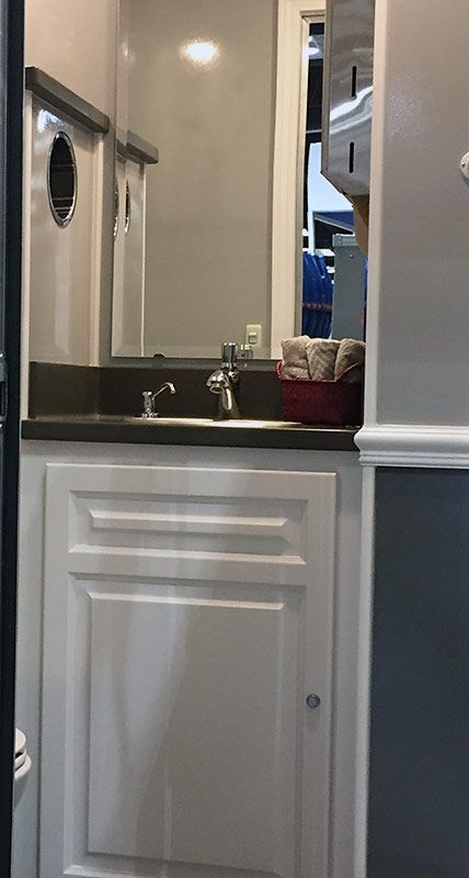 A bathroom with a sink , mirror and cabinets.