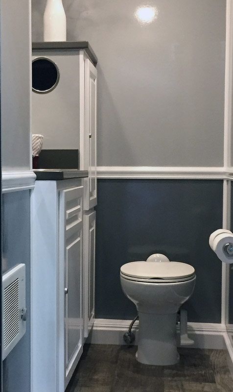 A bathroom with a toilet , sink , and toilet paper.