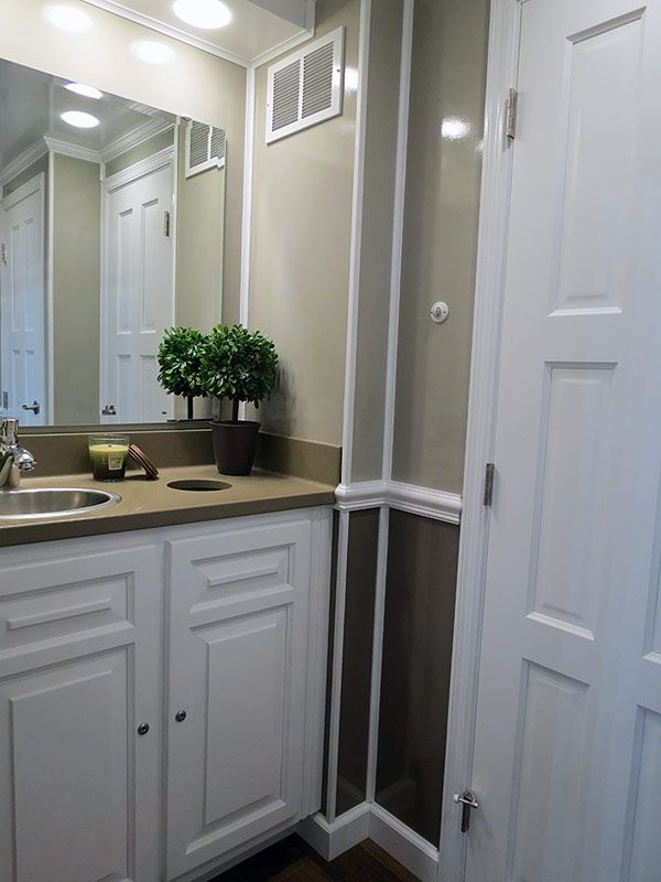 A bathroom with a sink , mirror and cabinets