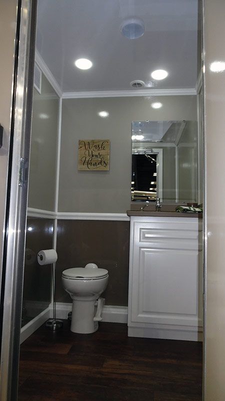 A bathroom with a toilet , sink and mirror.