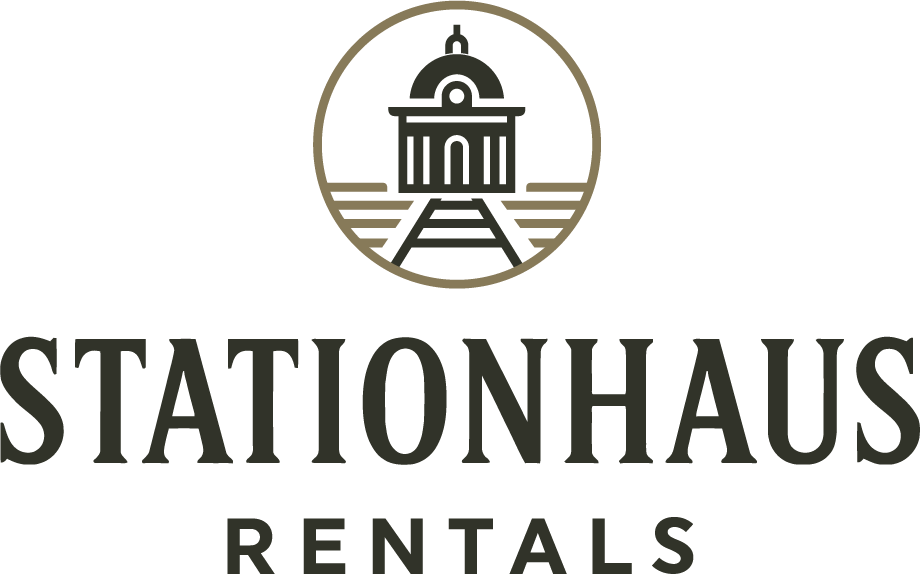 A logo for stationhaus rentals with a train and a building in a circle.