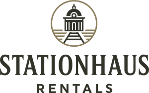A logo for stationhaus rentals with a train and a building in a circle.