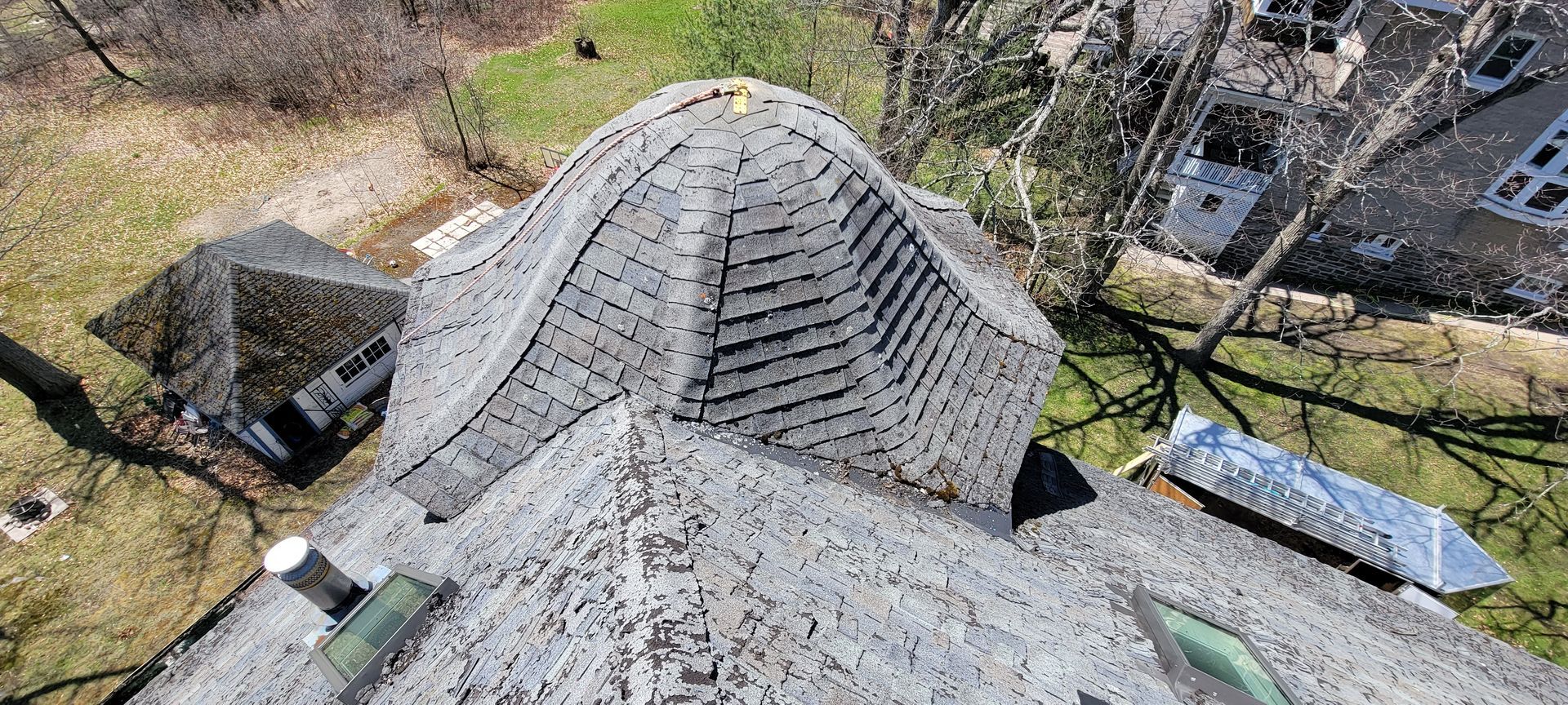 An aerial view of a roof with a few trees in the background.