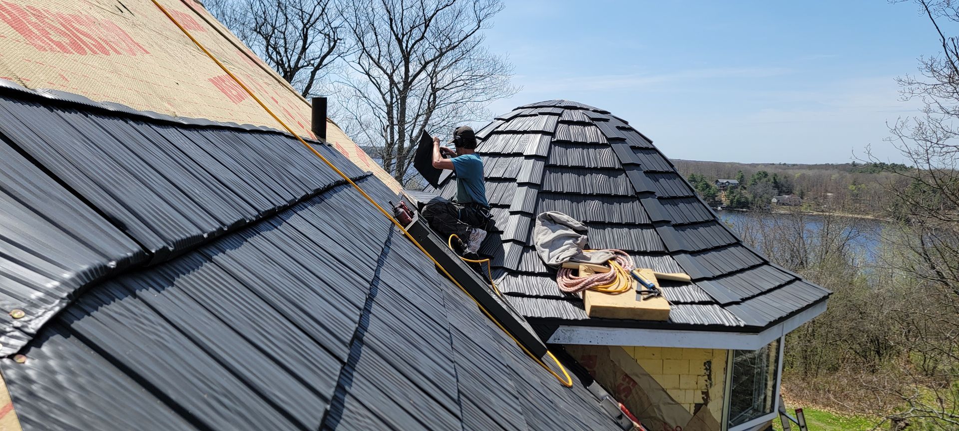 A man is working on the roof of a house.
