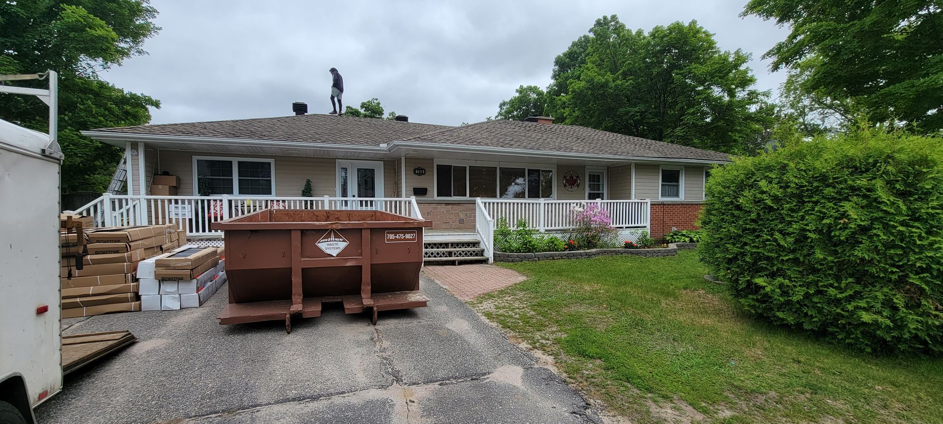 A large house with a dumpster in front of it.
