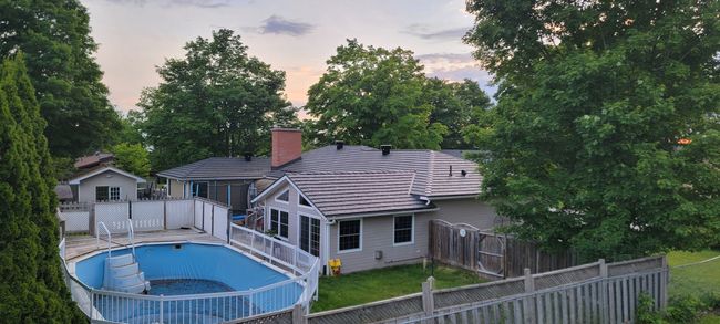 There is a large swimming pool in the backyard of a house.