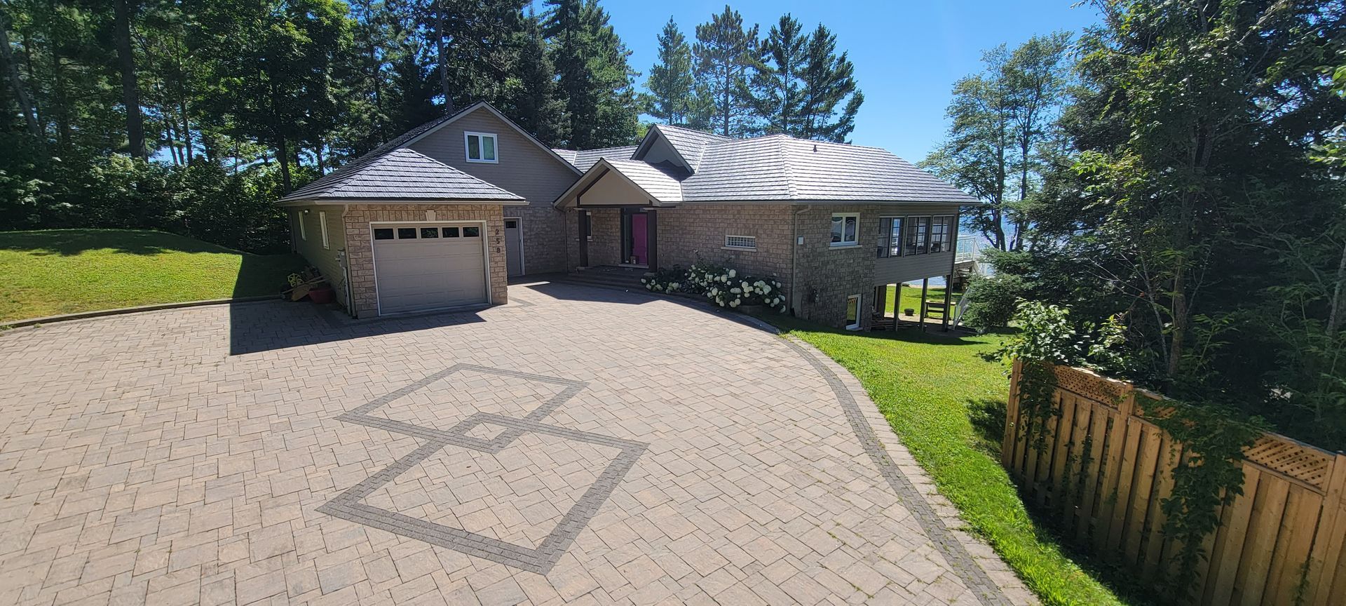 A large house with a brick driveway leading to it.