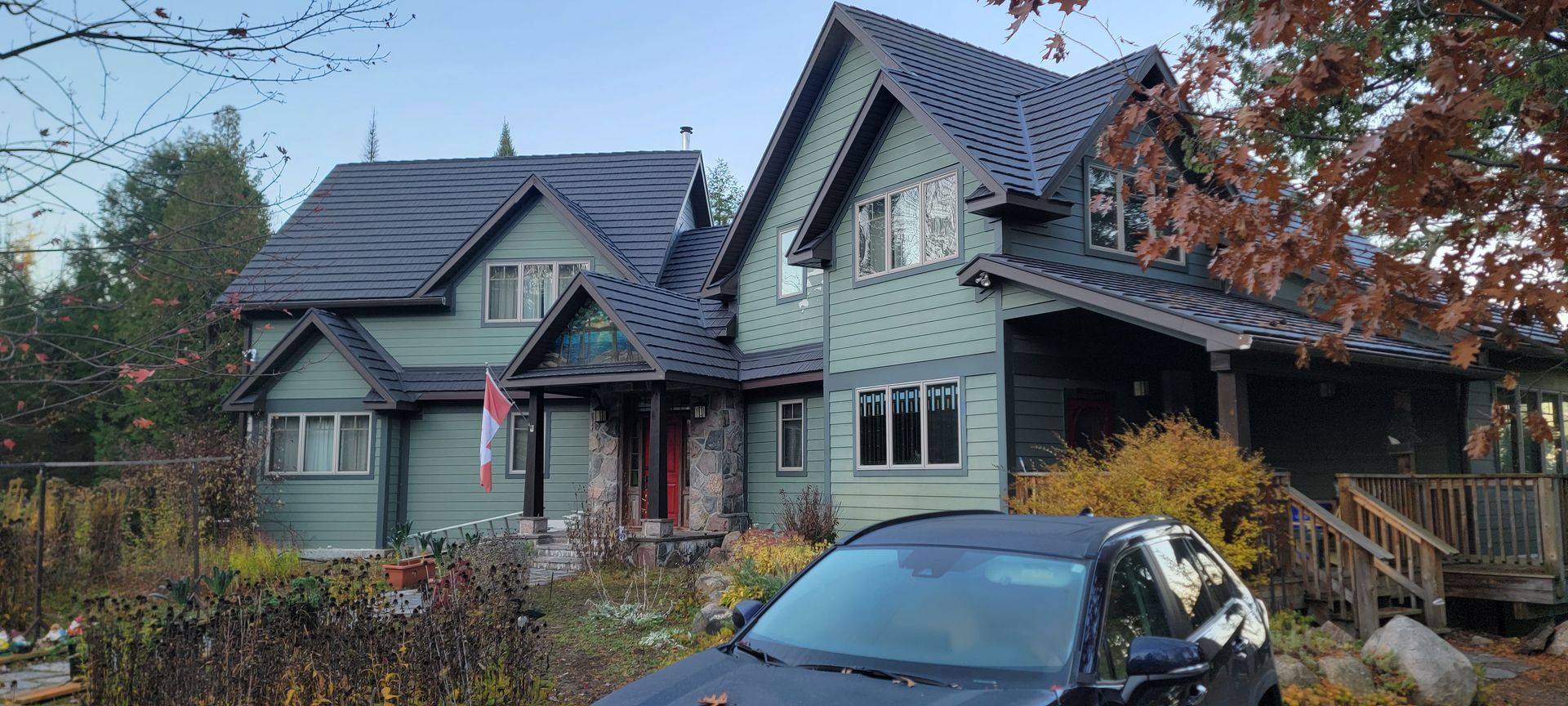 A car is parked in front of a large house.