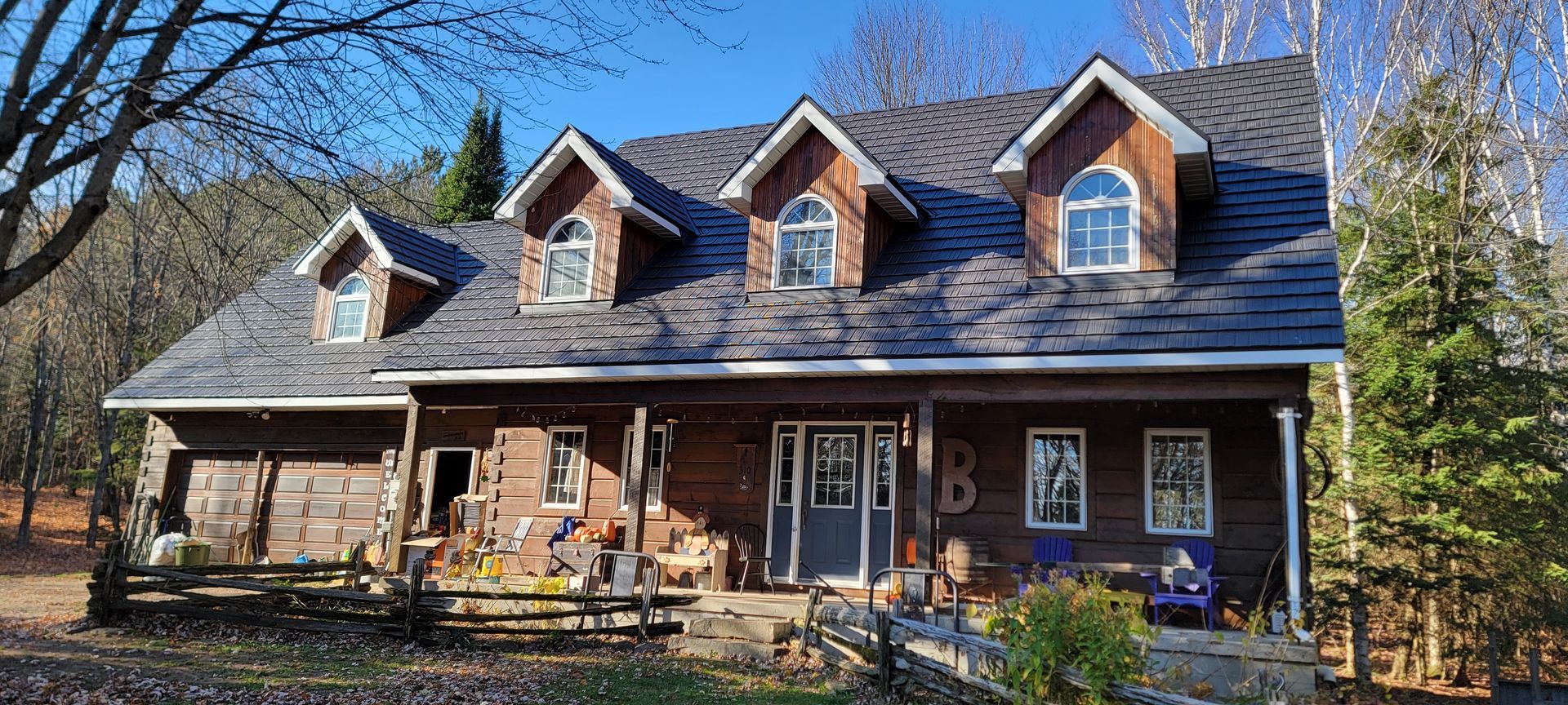 A large wooden house with a porch and a gray roof.