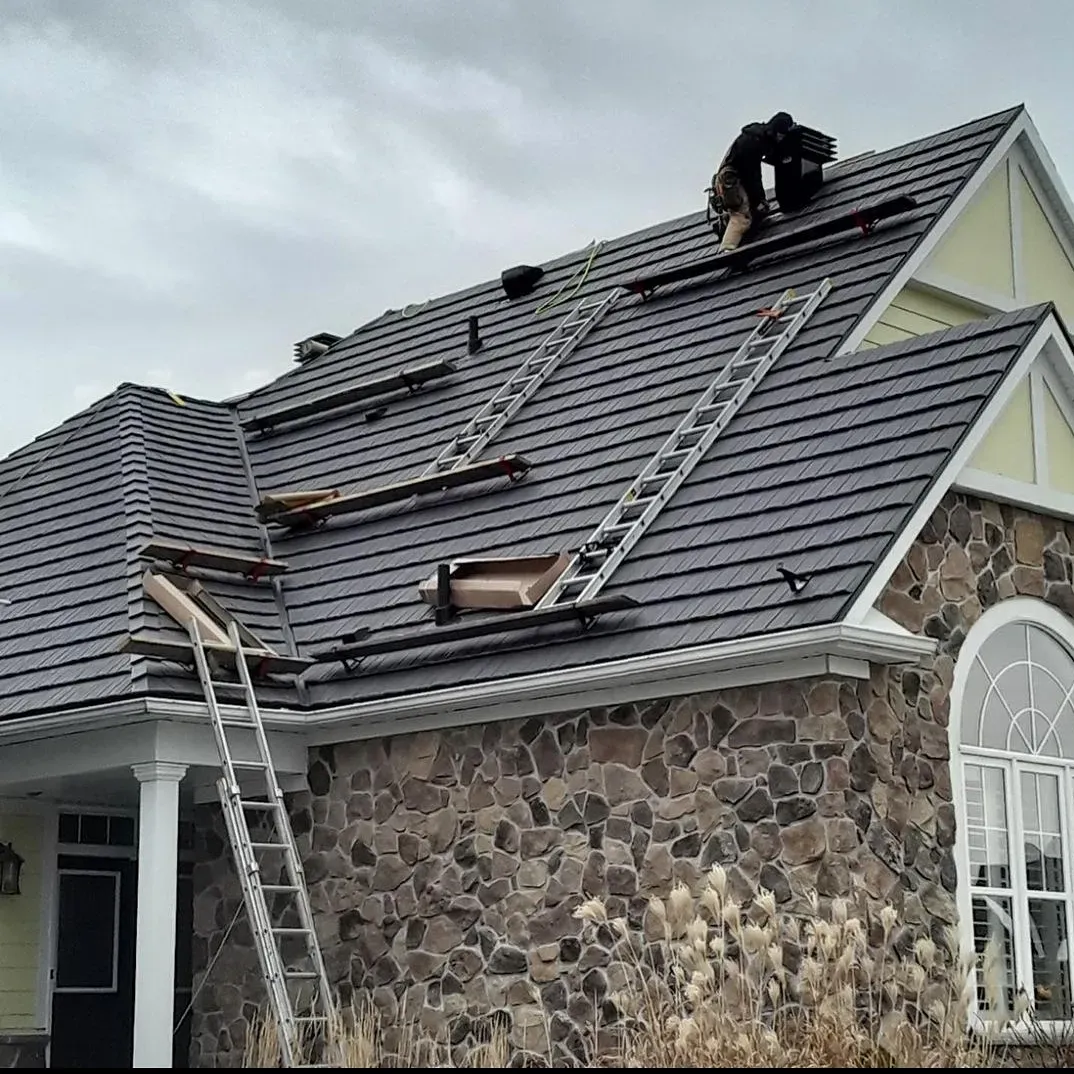 A man is working on the roof of a house.