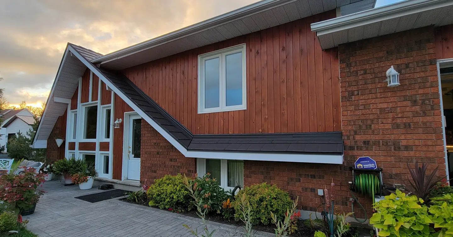 A large brick house with a wooden siding and a roof.