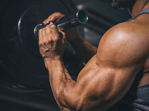 Un uomo solleva un bilanciere in palestra.