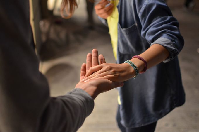 a woman wearing a blue bracelet holds a man 's hand