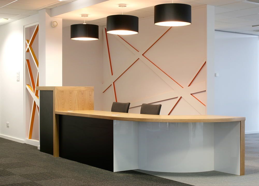 A Reception Desk in An Office with Three Lamps Hanging from The Ceiling — MD Designs in Bellambi, NSW