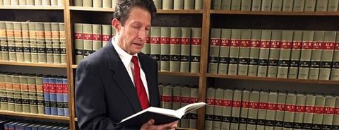 Lawyer Reading Law Book in a Law Library — Law Offices in Oak Ridge, TN