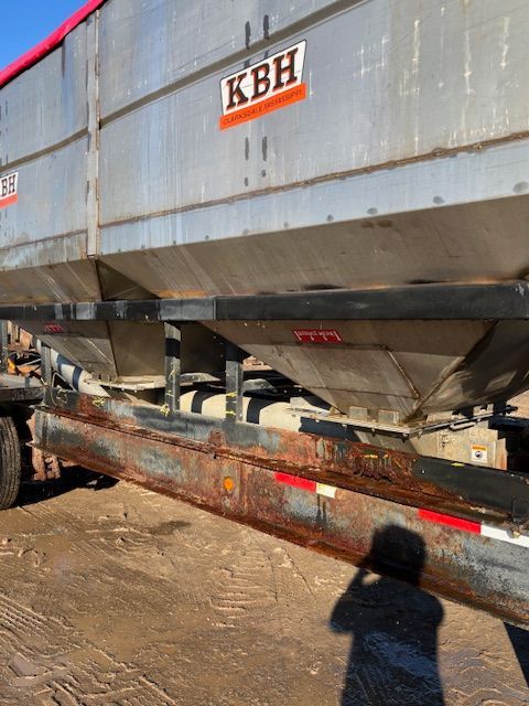 Silver KBH grain trailer with rust on the frame.