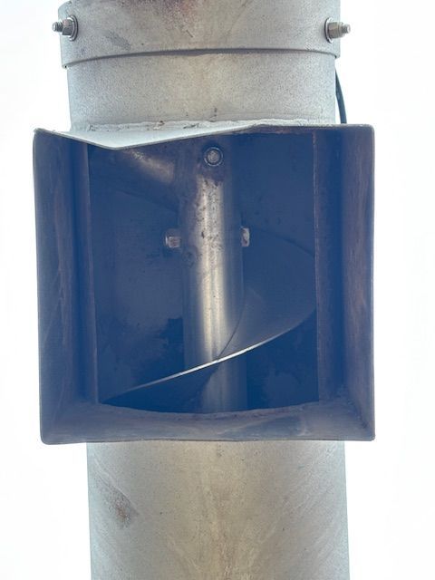 Metal post with a square opening revealing a curved metal mechanism inside.