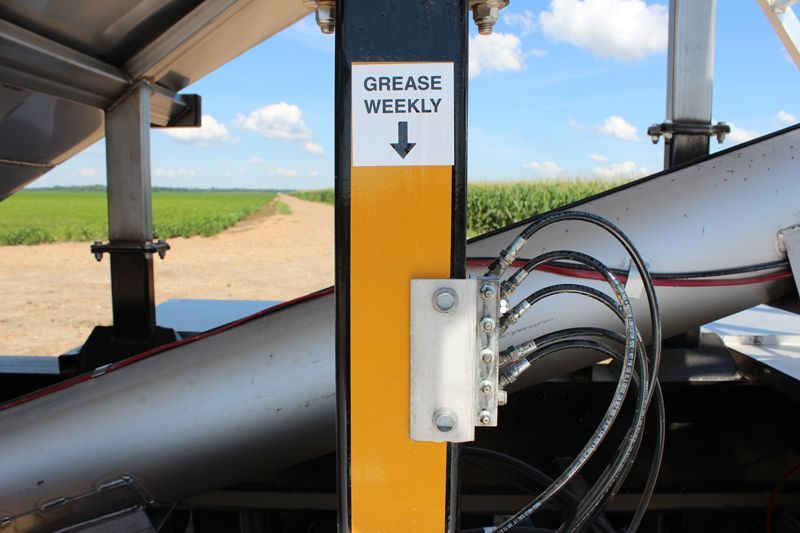 A yellow and black pole with a sign that says grease weekly