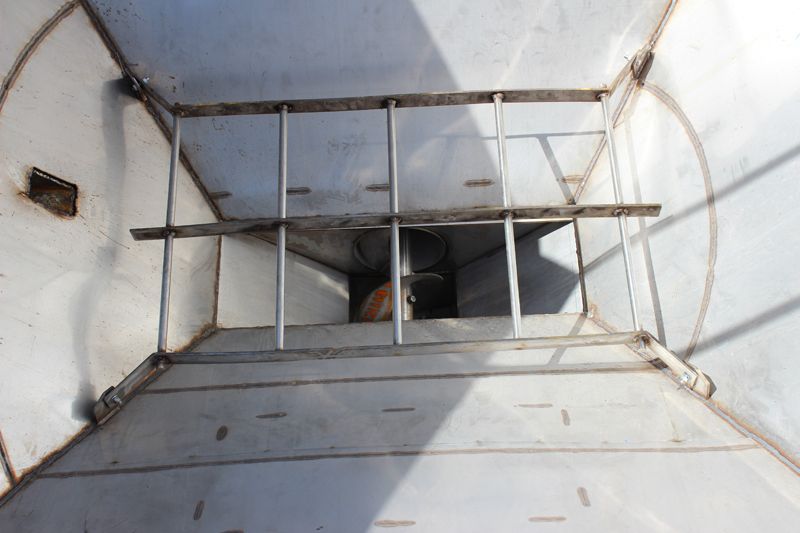 The inside of a metal container with a ladder leading up to it