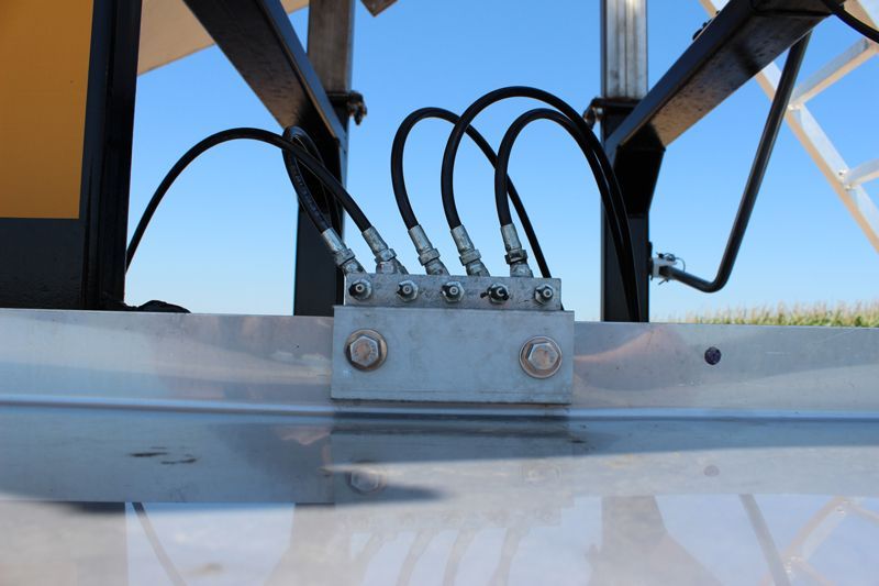 A close up of a metal structure with hydraulic hoses attached to it