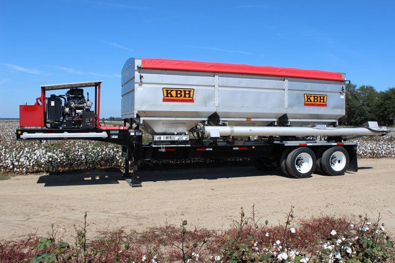A kbh trailer is parked in a field of cotton