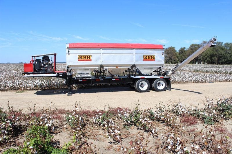 A semi truck is parked in a field of cotton.