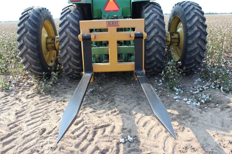 A john deere tractor with forks attached to it