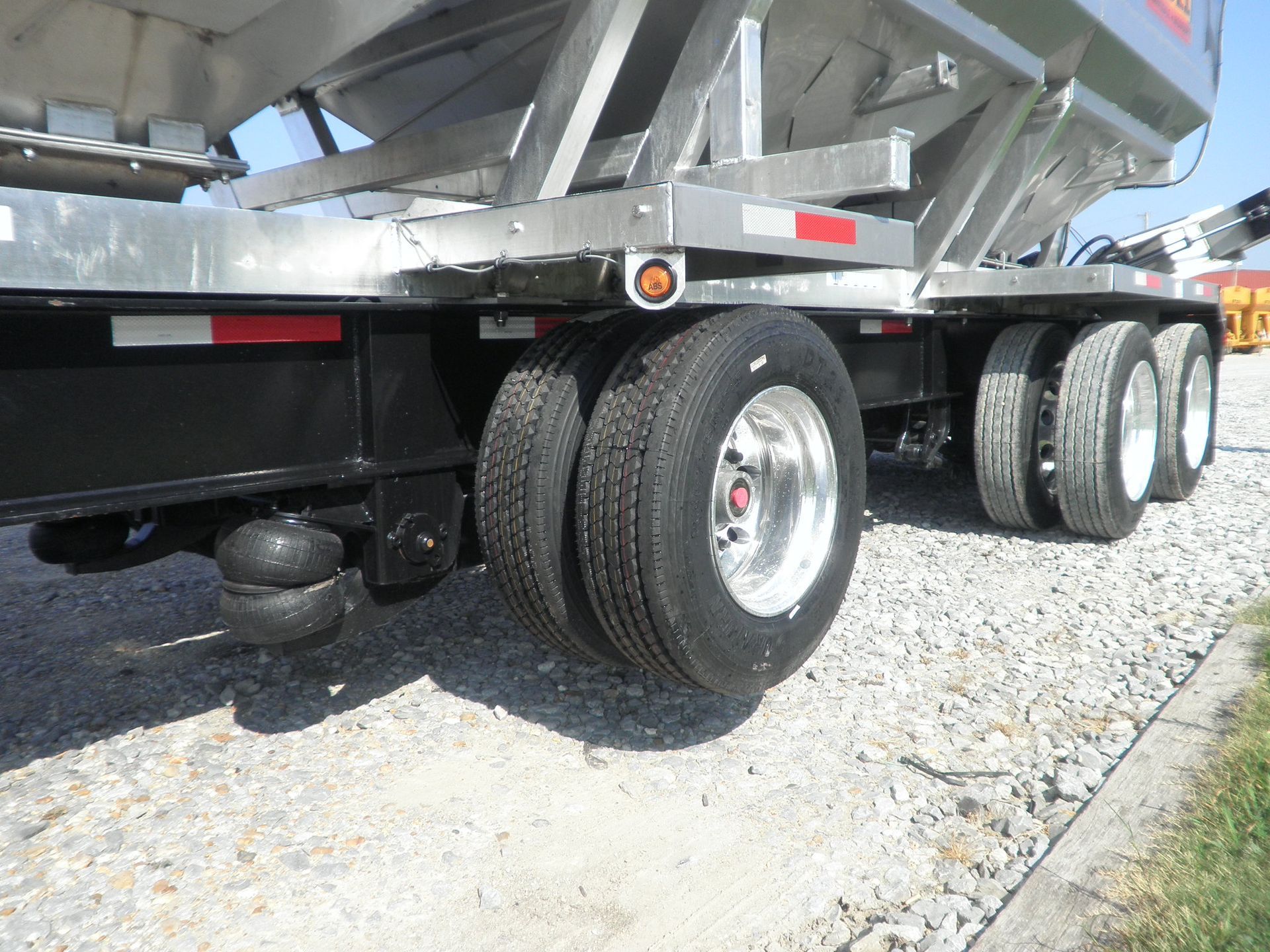 A semi truck is parked on a gravel road.