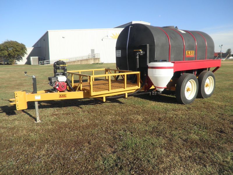 A trailer with a tank on it is parked in a grassy field