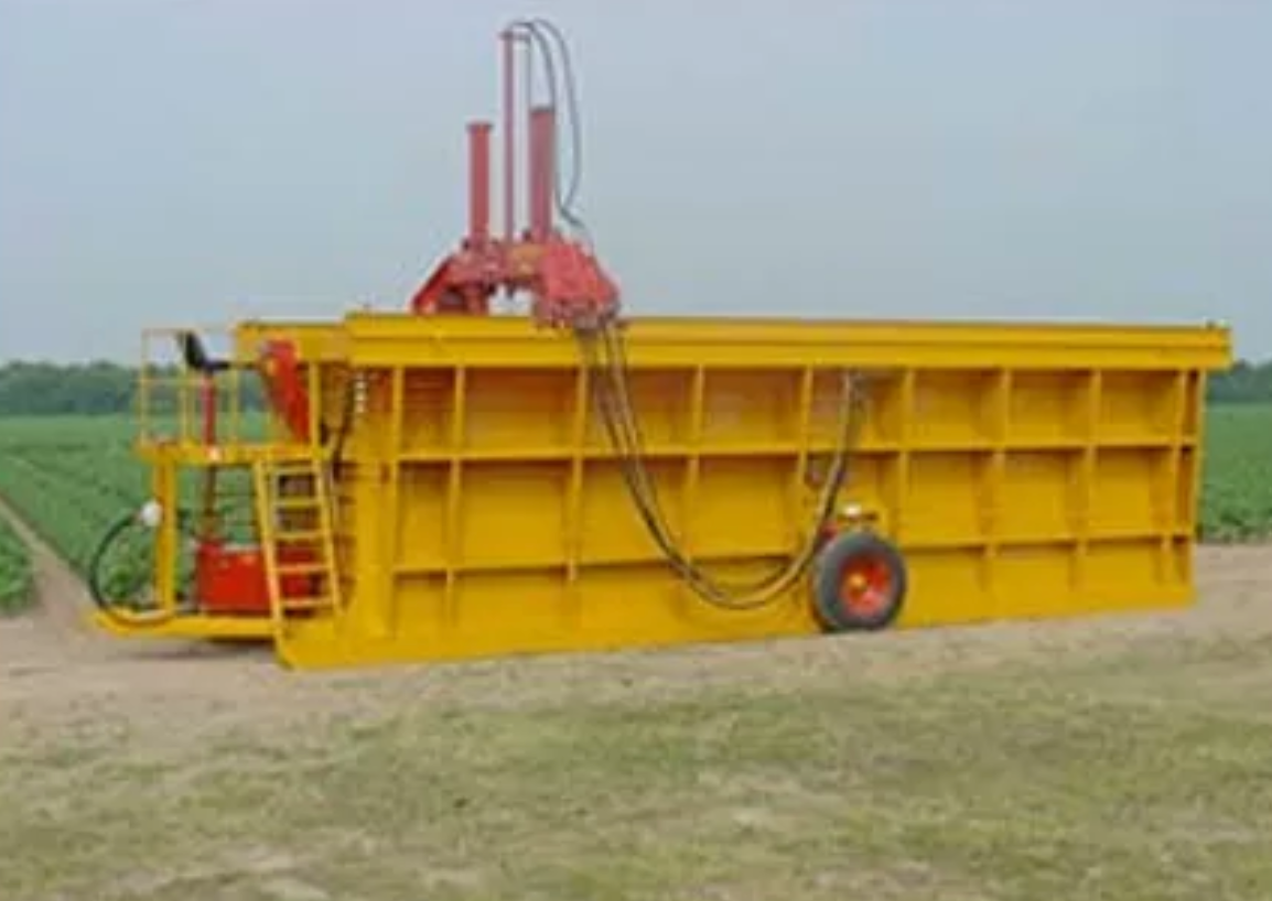 A large yellow container is parked in a field.