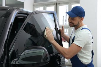 worker cleaning the car door