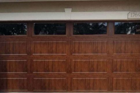 Wooden two-car garage door with frosted windows and house number 1769 above it