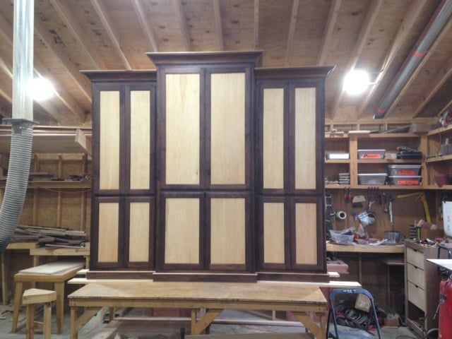 Wooden cabinet with light and dark panels, in a workshop.