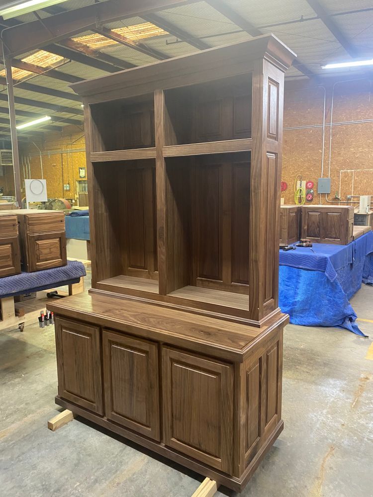 Wooden hutch with upper shelves and lower cabinets, in a workshop setting.