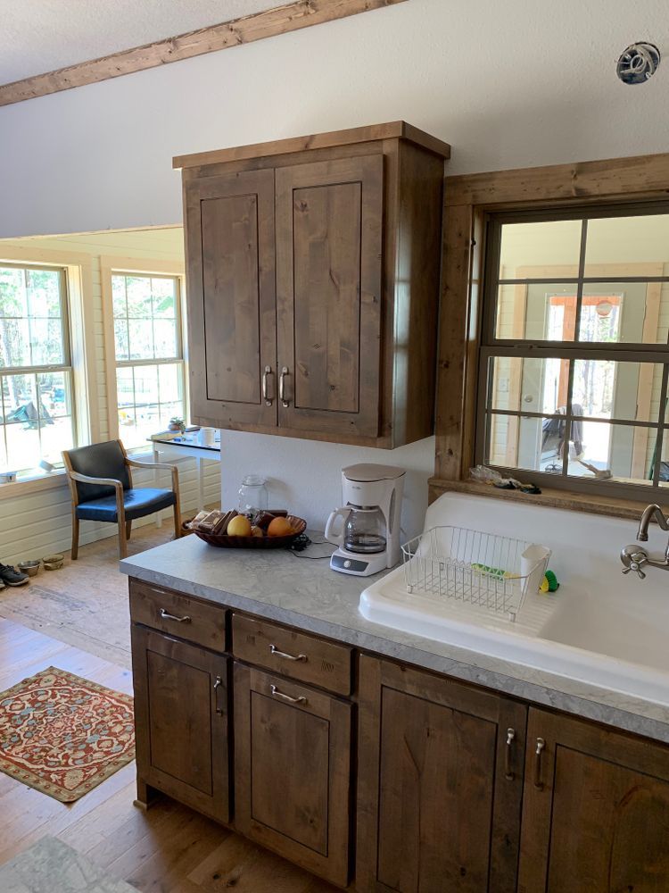 Kitchen with wooden cabinets, countertop, sink, and windows.