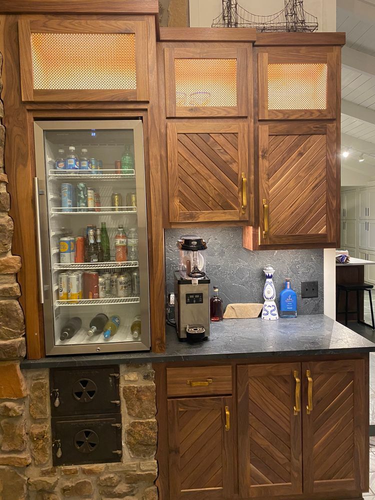 Wooden bar area with a cooler, cabinets, and a coffee machine.