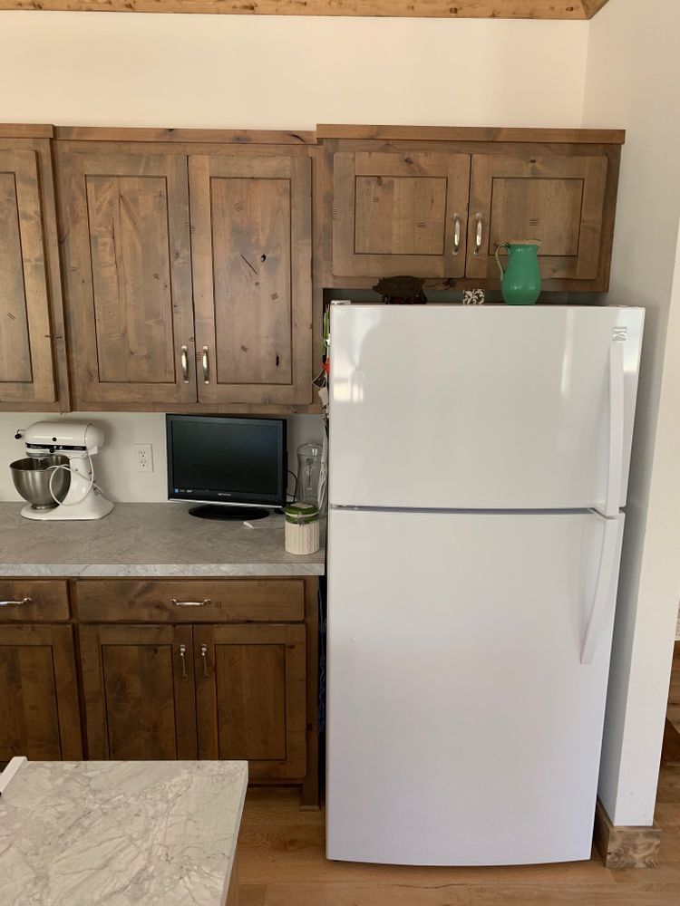 Kitchen with wood cabinets, white refrigerator, and countertop with a stand mixer.